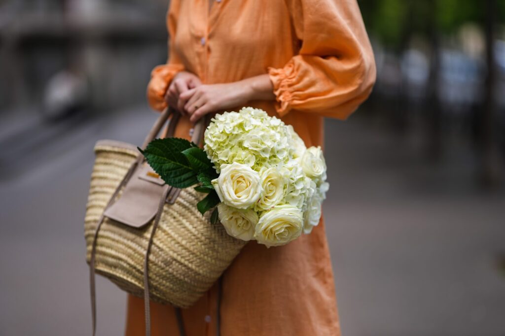 une femme avec un bouquet de fleurs dans la main