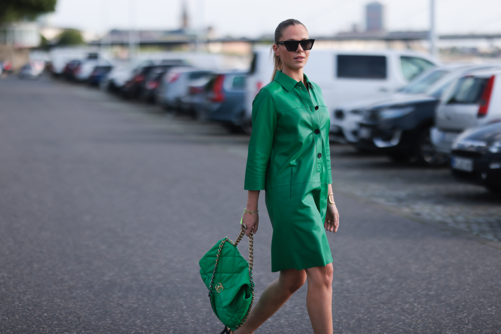 Femme dans un tailleur en cuir vert et un sac à main vert