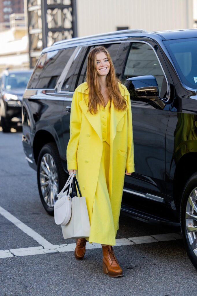 Olivia Jauretche en look jaune, bottines à lacets marron et sac à main gris