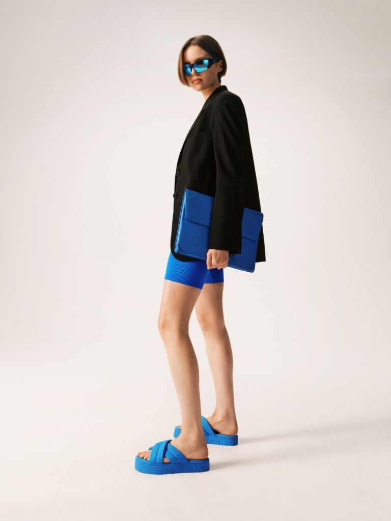 Style avec un blazer noir, un short bleu assorti et des tongs à plateforme de la même couleur.
