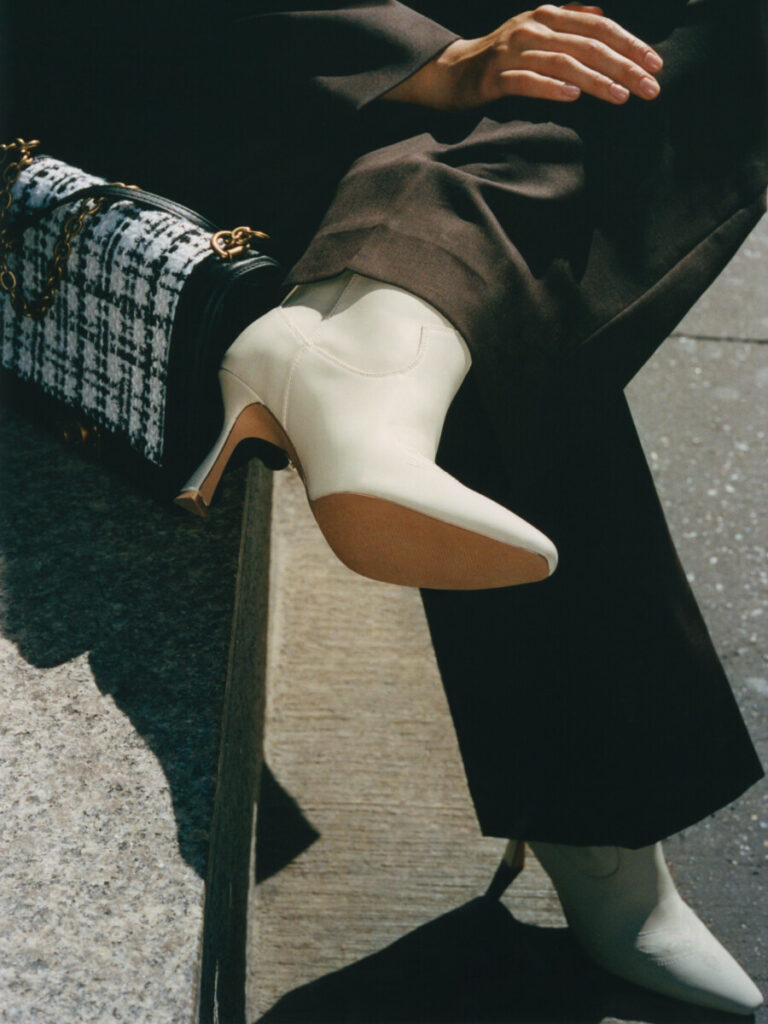 mannequin avec un sac à main nine west et des bottines blanches
