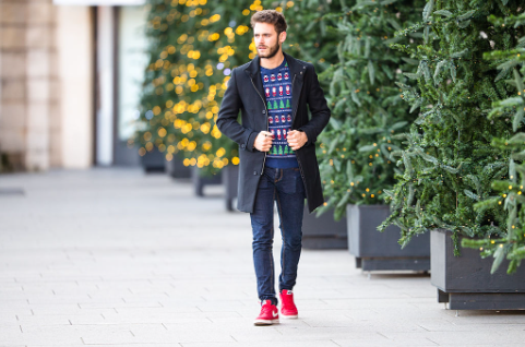 Homme portant un pull à motifs et des sneakers rouges